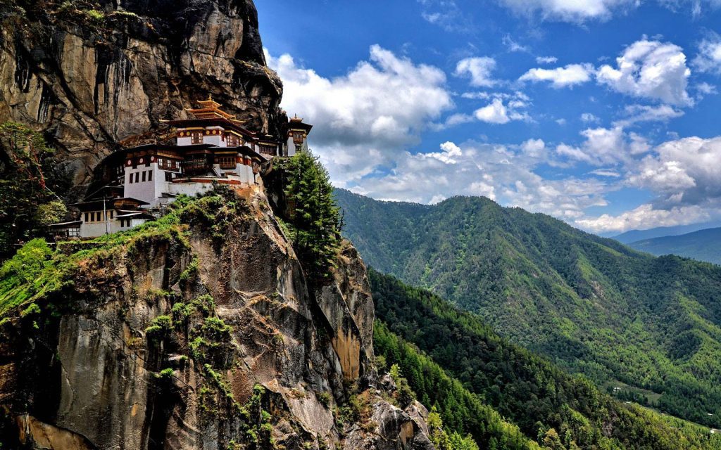 Tiger's Nest Monastery, Bhutan, perched on a cliff at dawn. A famous hike with scenic mountain views and a blue sky.