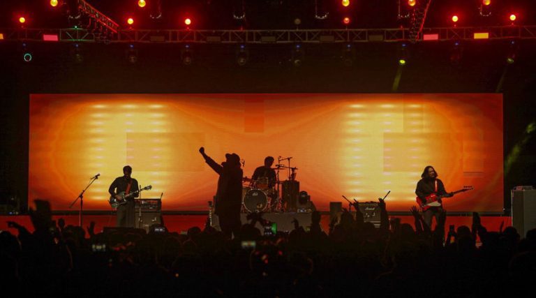 Asia Rock Fest: A band performs on stage at a music festival in Bhutan, with a large crowd enjoying the concert.